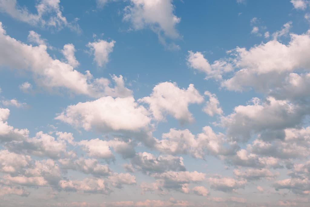 White clouds across a blue midday sky